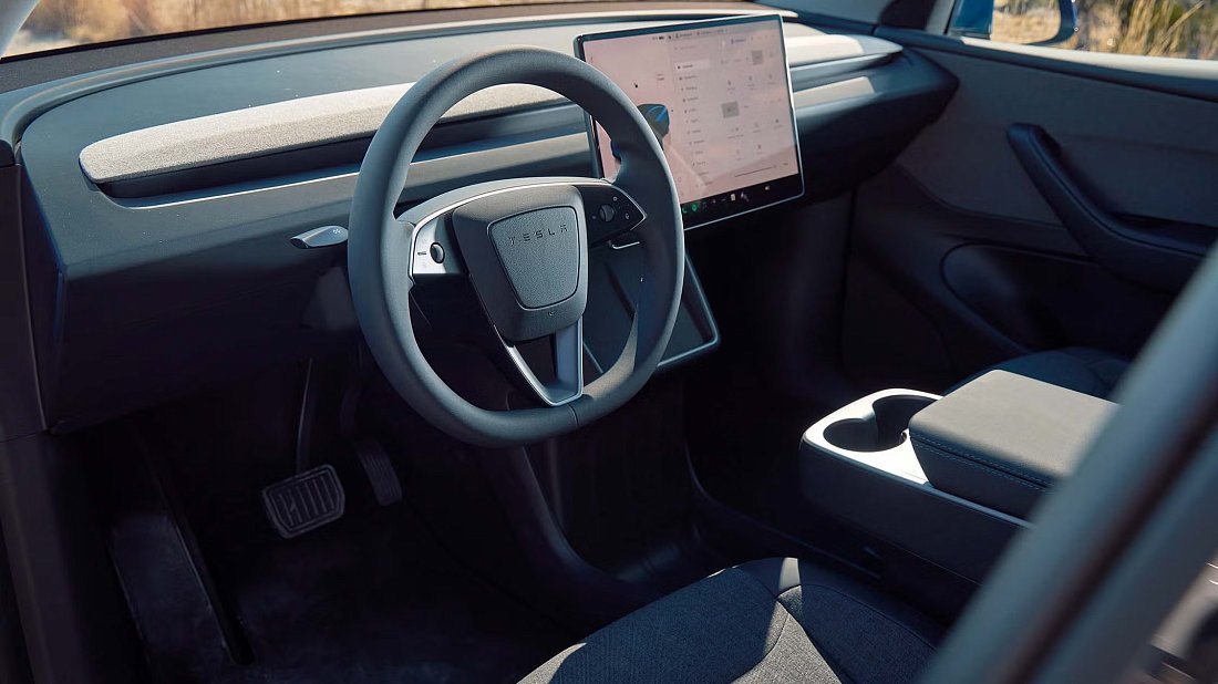 Tesla Model Y Standard RWD (2025-...) interior photo, front seat, driver seat, dashboard, steering wheel, infotainment, cockpit
